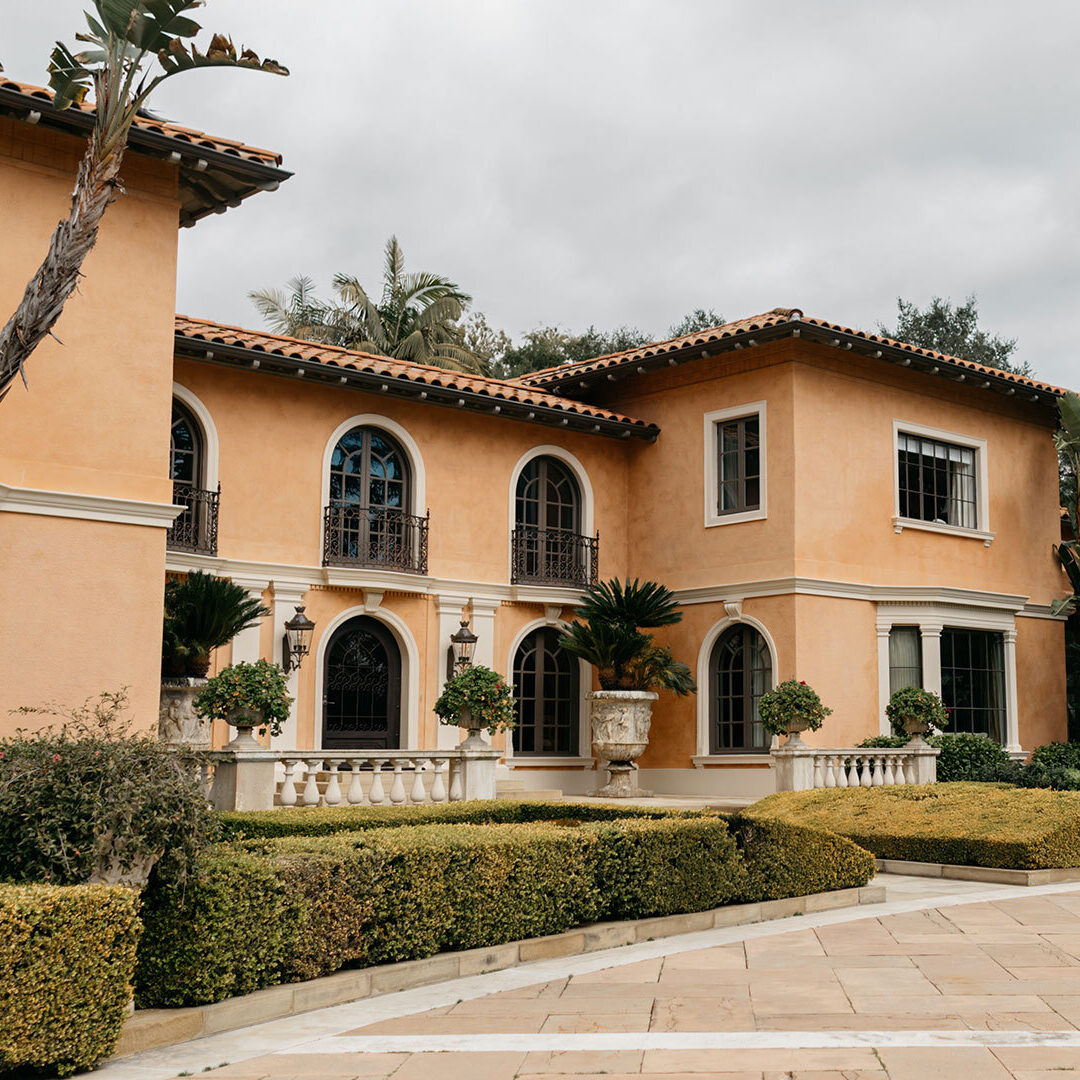 A photo of the front of a large mediterranean style house.
