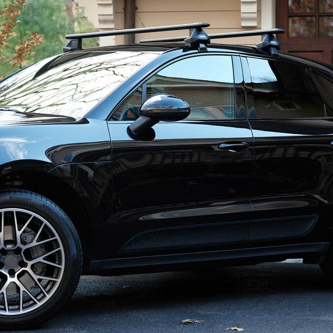 A photo of a black luxury SUV parked in front of a home garage.