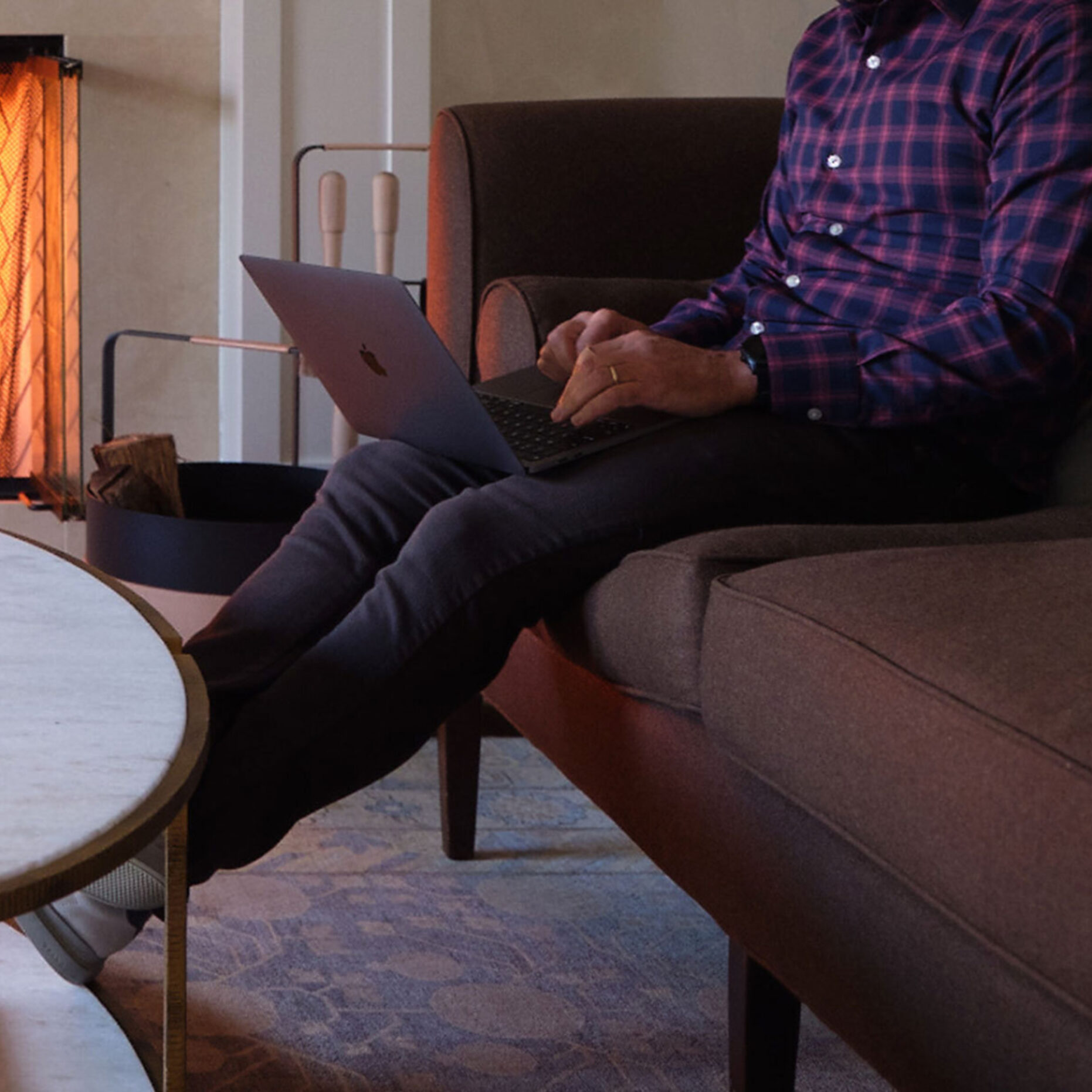 A close-up photo of a man on a laptop in his living room.