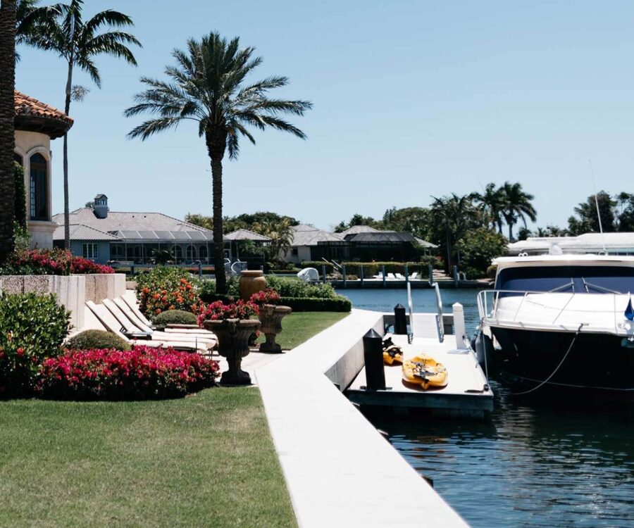 A photo of a small boat docked in the backyard of a luxurious Florida home.