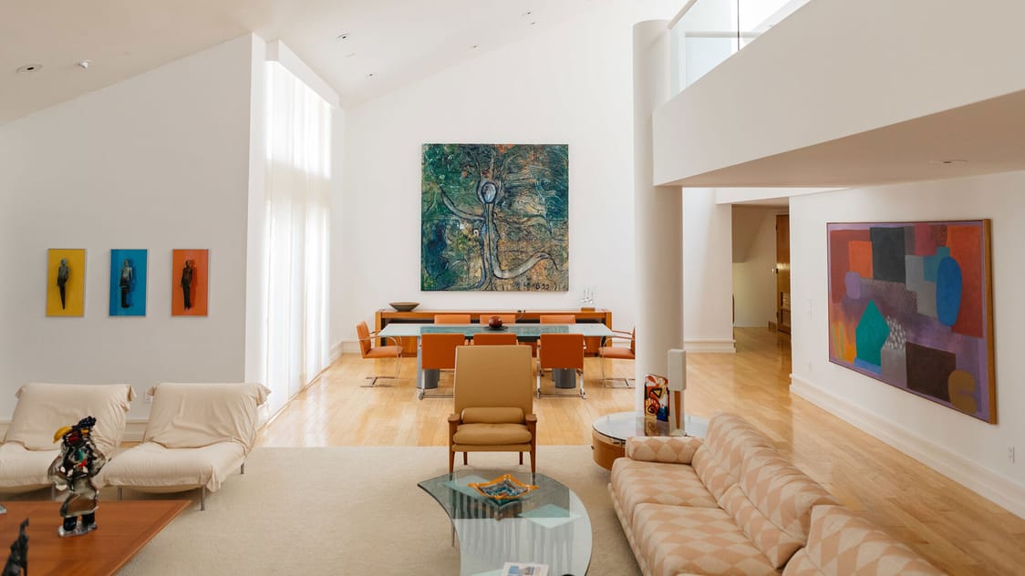 A photograph of the interior of a bright, modern home decorated with colorful modern art.