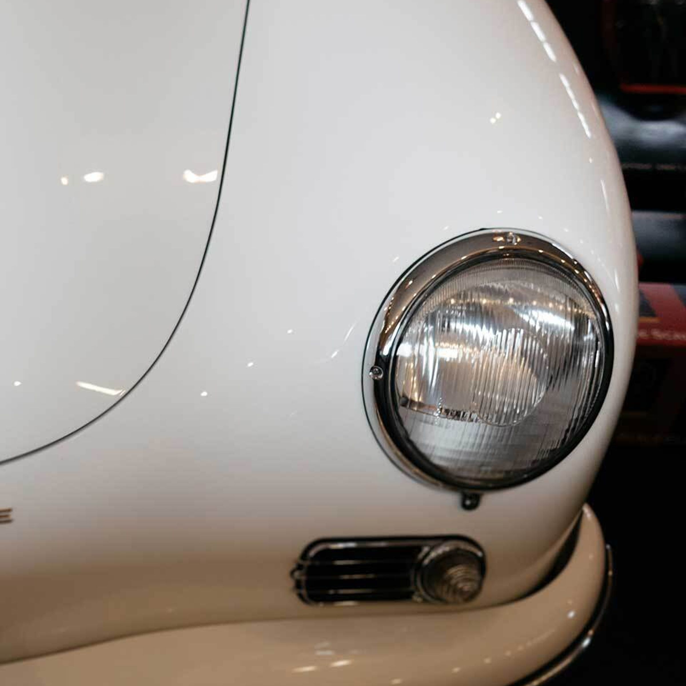 A close-up photo of the headlight and bumper of a rare sports car