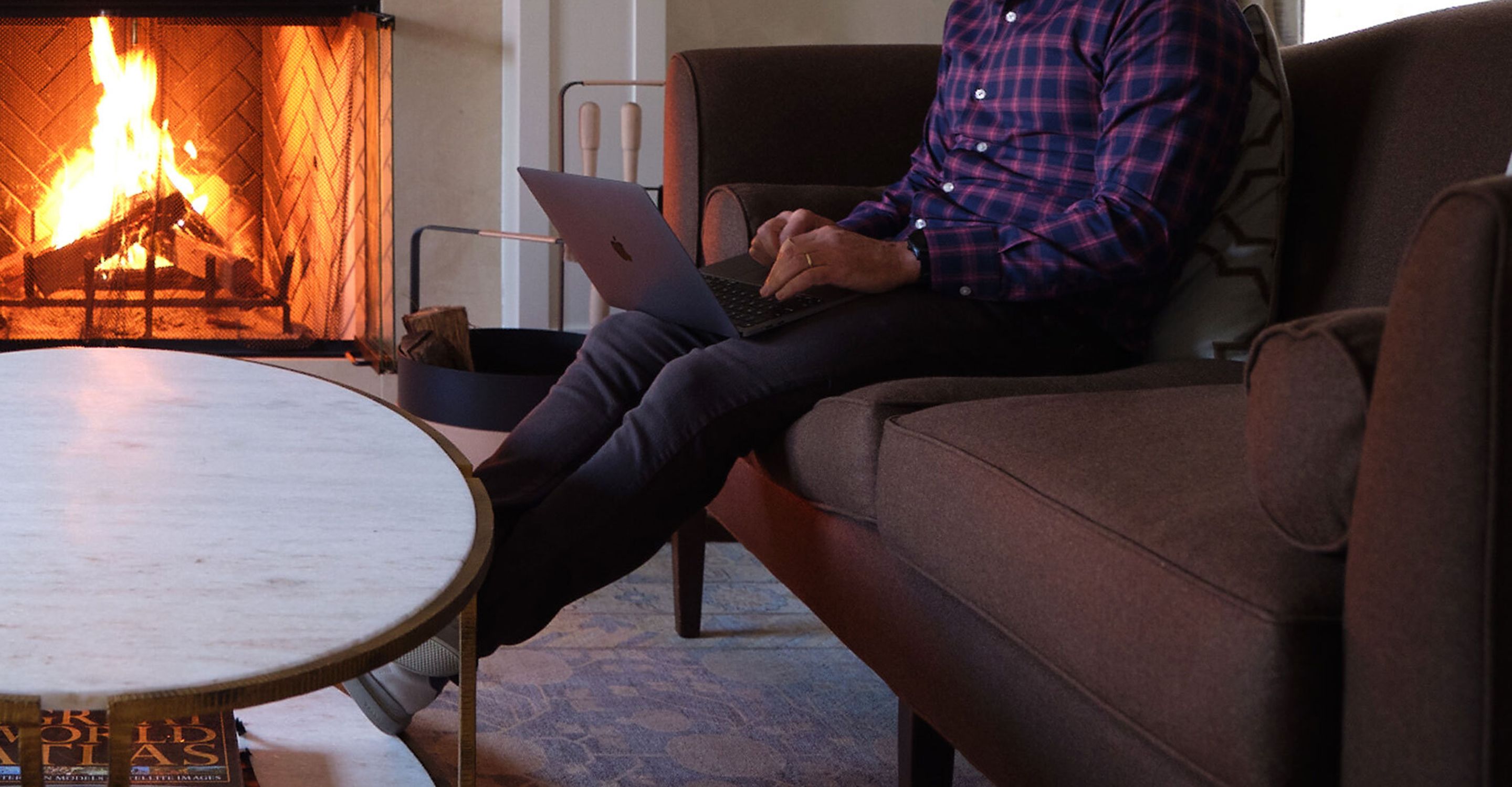 A close-up photo of a man on a laptop in his living room.
